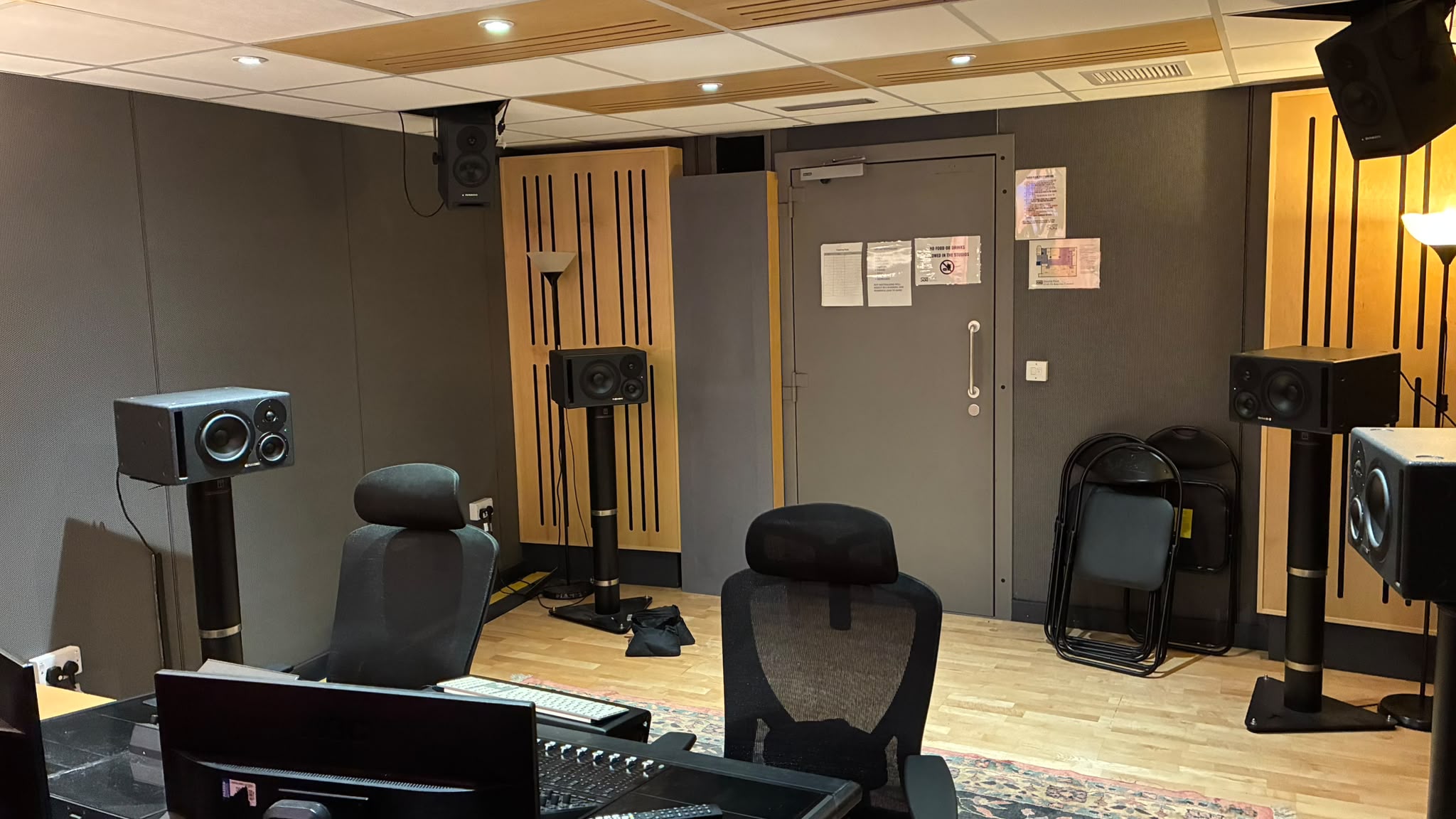 Wide view of the Dolby Atmos room with speakers and seating.